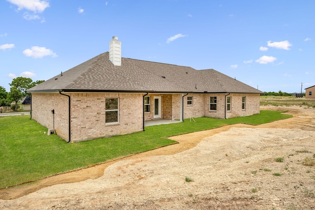 back of property with a patio area and a yard