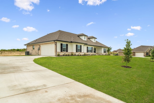 view of front of house with a front yard, central AC, and a garage