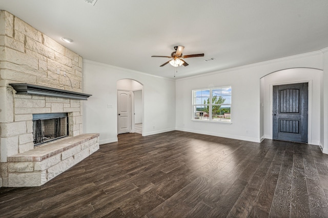 unfurnished living room with dark hardwood / wood-style floors, ceiling fan, ornamental molding, and a fireplace