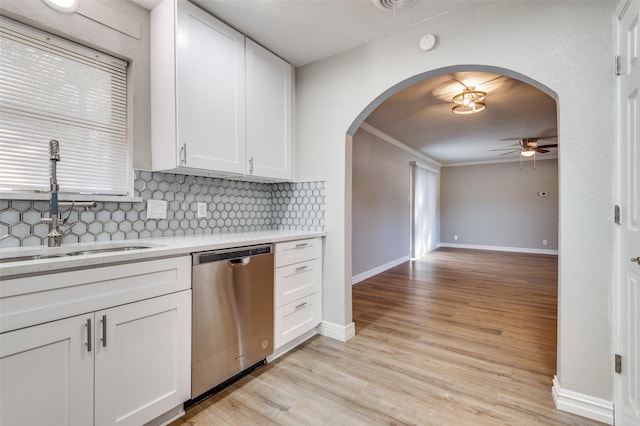 kitchen featuring backsplash, stainless steel dishwasher, crown molding, sink, and white cabinets