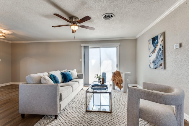 living room featuring ceiling fan, light hardwood / wood-style flooring, ornamental molding, and a textured ceiling