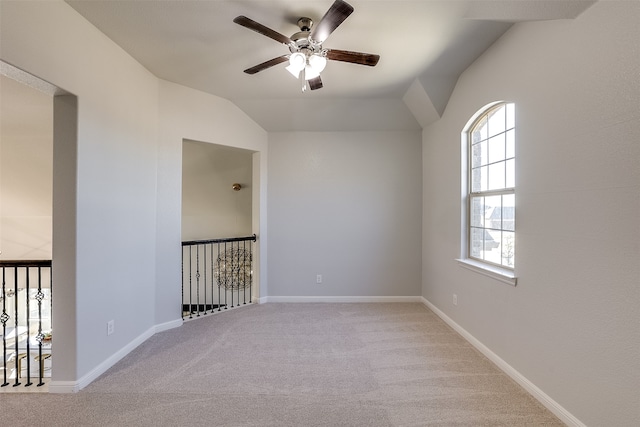 carpeted spare room featuring ceiling fan and vaulted ceiling