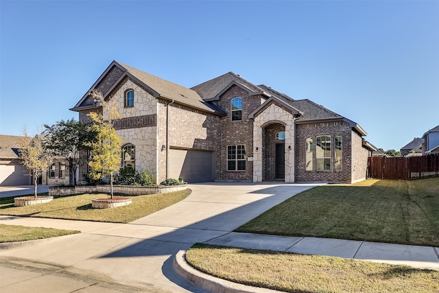 french provincial home featuring a front yard and a garage