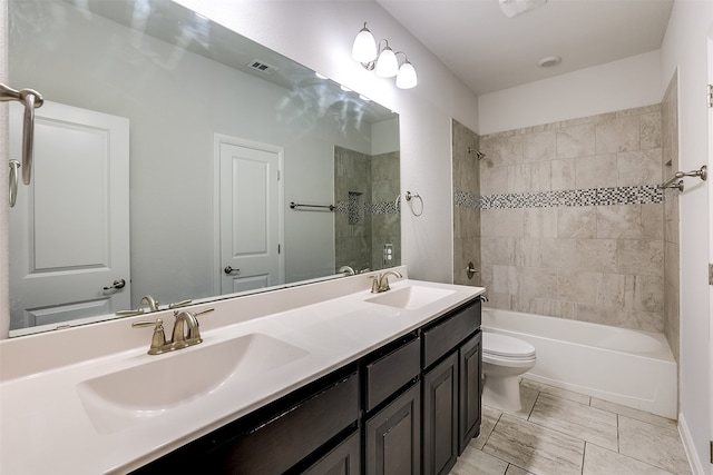 full bathroom featuring toilet, vanity, and tiled shower / bath combo