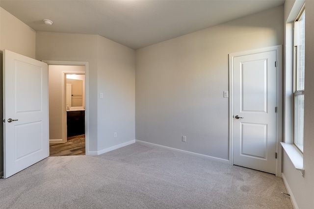 unfurnished bedroom featuring light carpet