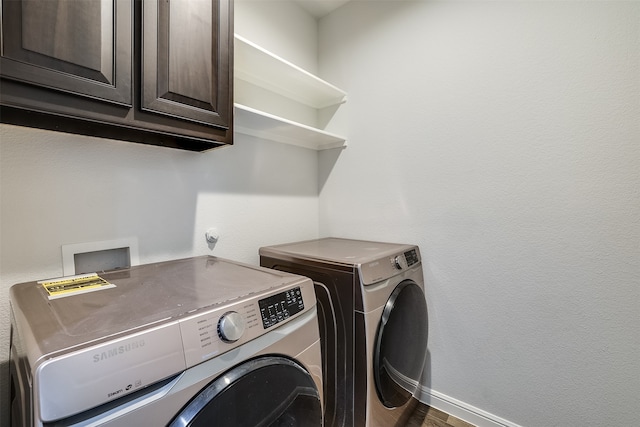 clothes washing area with cabinets, independent washer and dryer, and dark wood-type flooring