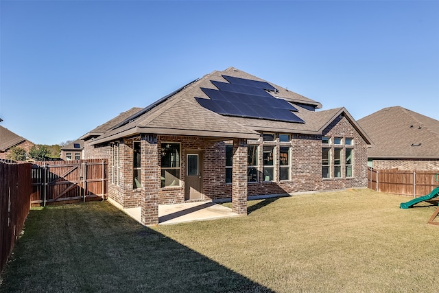 rear view of property with solar panels, a yard, and a patio