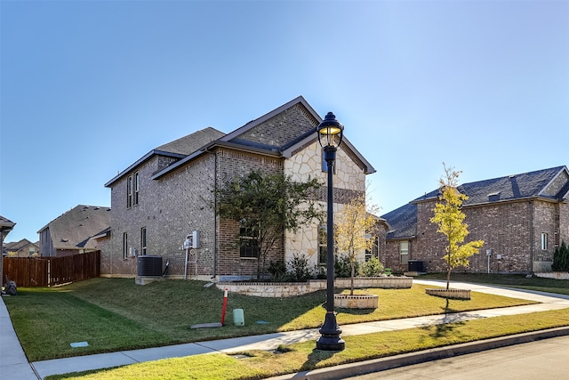 view of front of house with a front yard and cooling unit