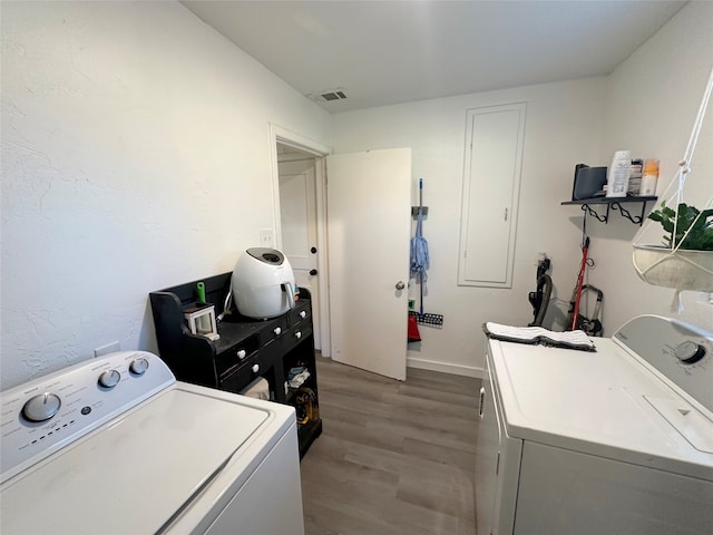 laundry area featuring washing machine and dryer and light wood-type flooring