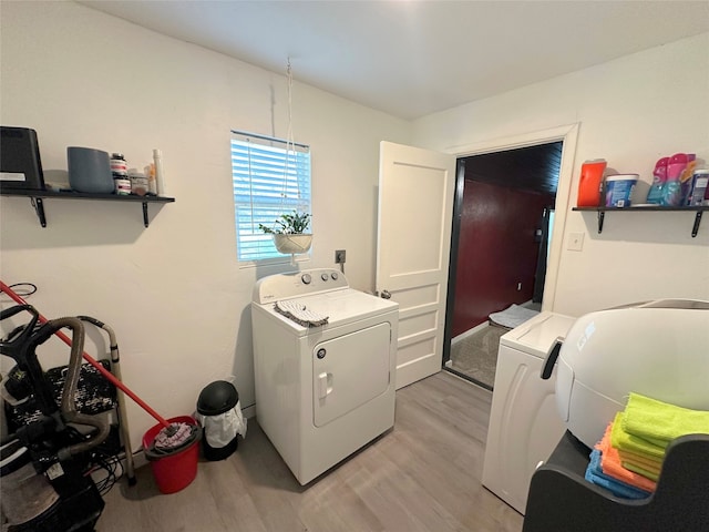 washroom featuring light hardwood / wood-style flooring and washing machine and clothes dryer