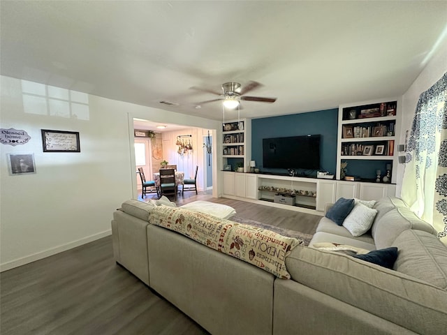 living room with built in shelves, ceiling fan, and wood-type flooring