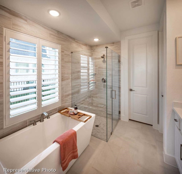 bathroom featuring vanity, a wealth of natural light, and independent shower and bath