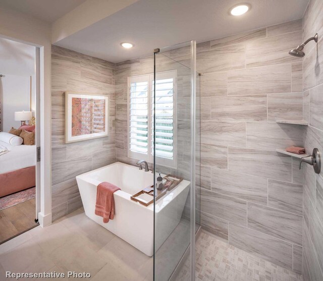 bathroom featuring tile walls and independent shower and bath