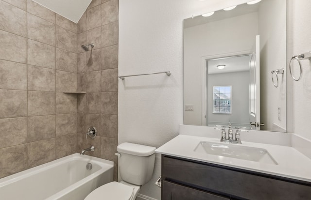 full bathroom with vanity, tiled shower / bath combo, and toilet