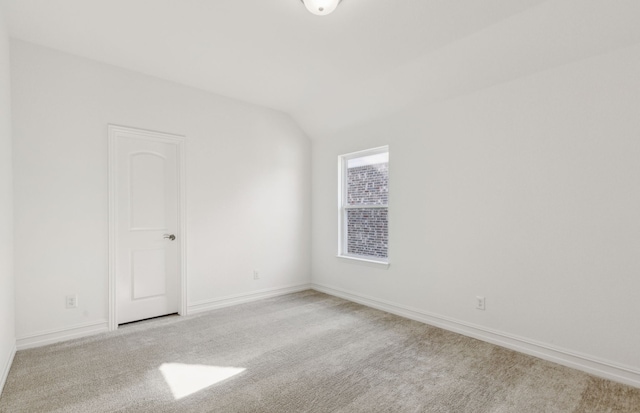 unfurnished room with light carpet and vaulted ceiling