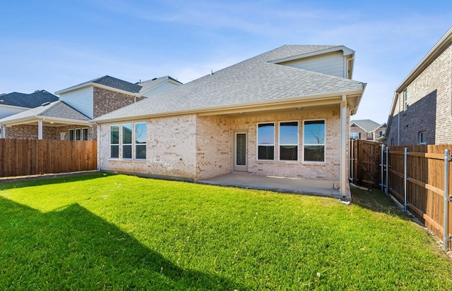 rear view of house with a yard and a patio area