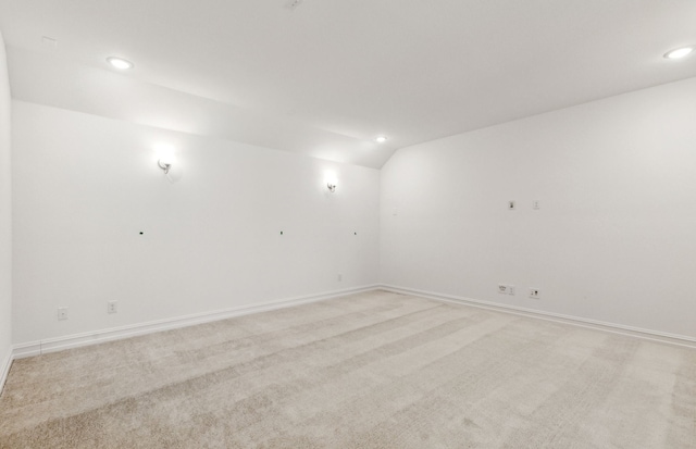 unfurnished room with lofted ceiling and light colored carpet