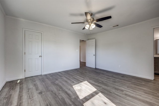 unfurnished bedroom with ensuite bathroom, light hardwood / wood-style flooring, ceiling fan, and ornamental molding