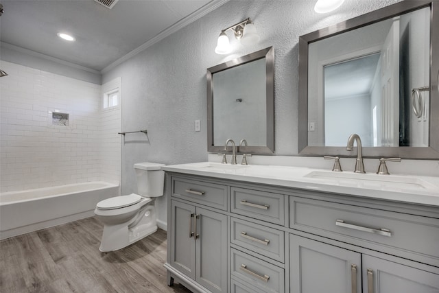 full bathroom with crown molding, hardwood / wood-style floors, toilet, vanity, and tiled shower / bath