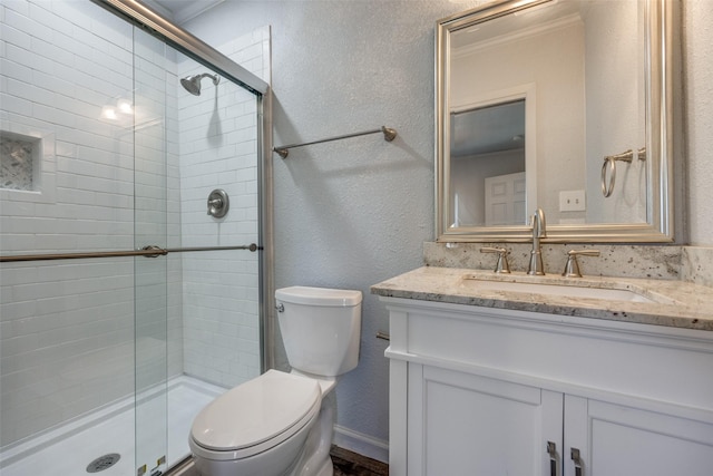 bathroom featuring vanity, toilet, an enclosed shower, and crown molding