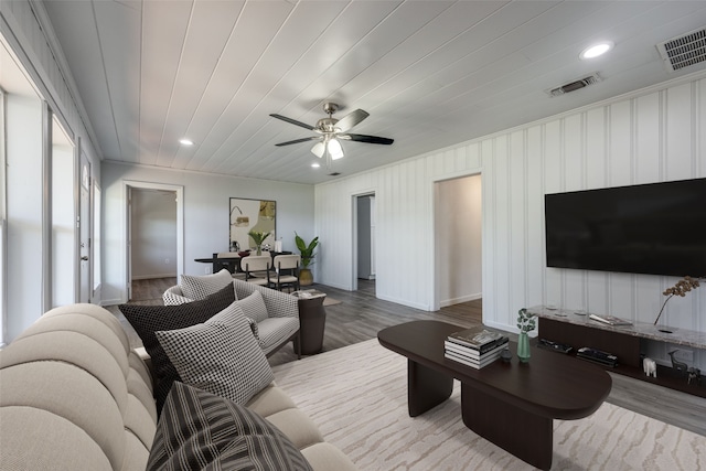 living room featuring ceiling fan, wood-type flooring, and crown molding