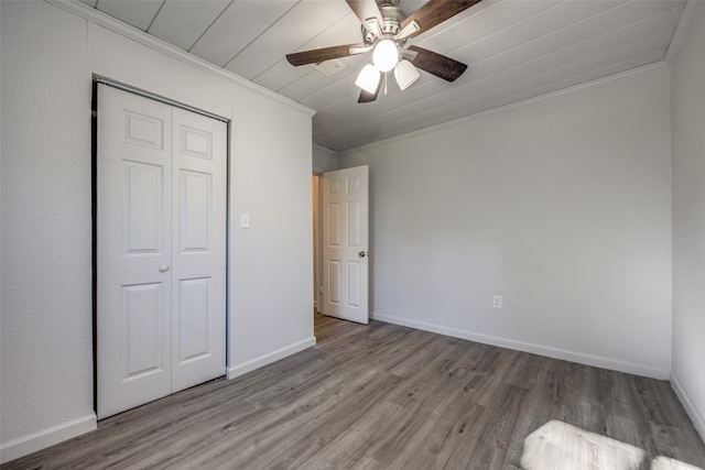 unfurnished bedroom featuring a closet, light hardwood / wood-style flooring, ceiling fan, and crown molding