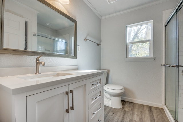 bathroom featuring vanity, a shower with door, crown molding, hardwood / wood-style flooring, and toilet