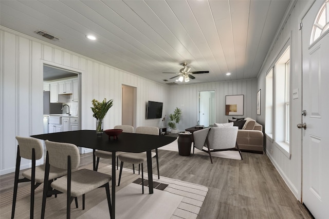 dining area with ceiling fan, sink, and light hardwood / wood-style flooring