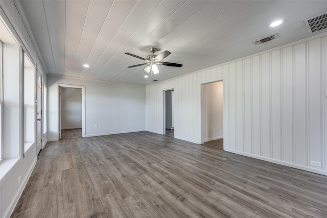 unfurnished room with wood-type flooring, ornamental molding, ceiling fan, and a healthy amount of sunlight