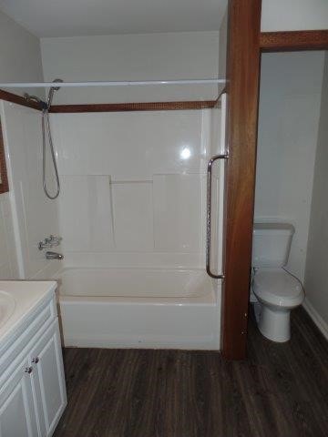 full bathroom with hardwood / wood-style flooring, vanity, toilet, and shower / bathing tub combination