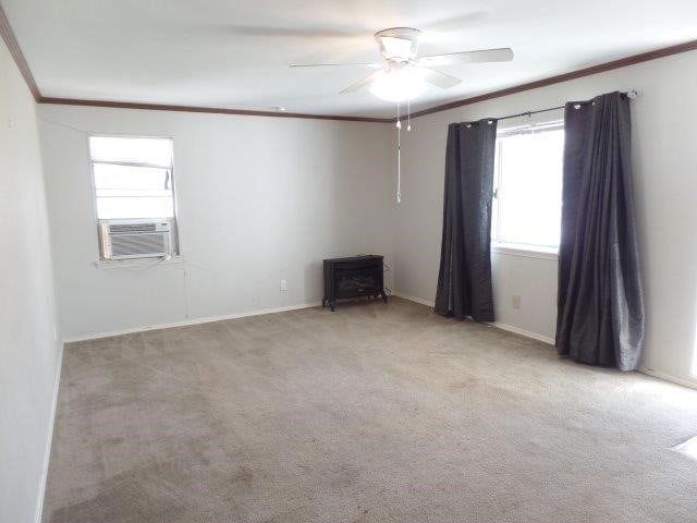 carpeted empty room featuring ceiling fan, cooling unit, and ornamental molding