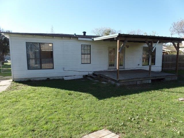 rear view of house featuring a lawn