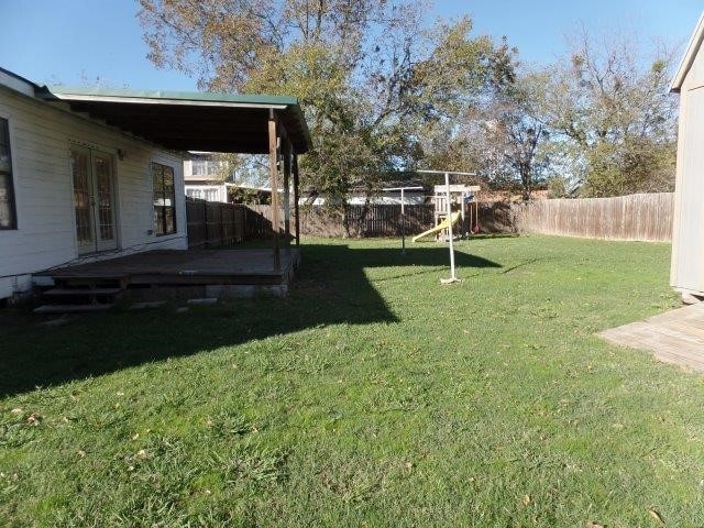 view of yard with french doors and a deck