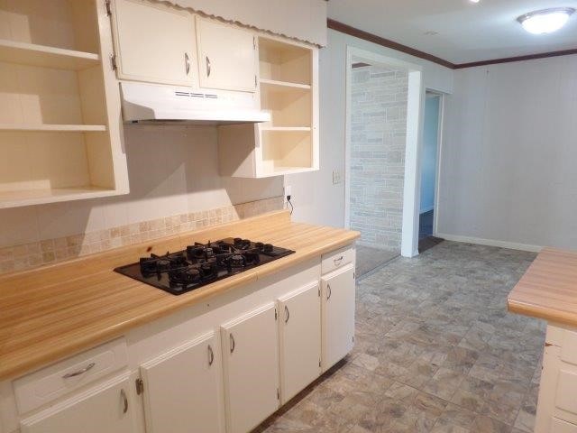 kitchen featuring white cabinets, black gas cooktop, and crown molding