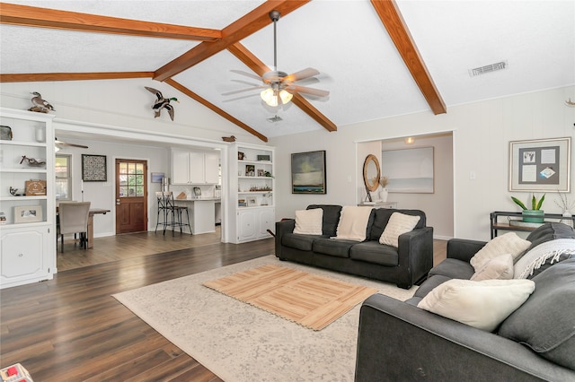 living room with ceiling fan, dark wood-type flooring, and lofted ceiling with beams