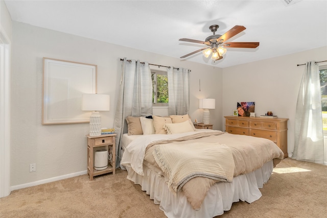 bedroom with ceiling fan and light carpet