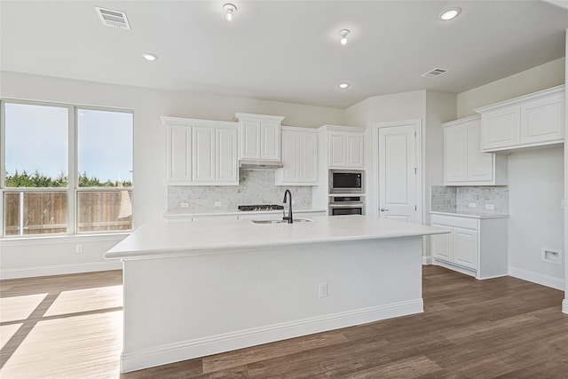 kitchen with a center island with sink, dark hardwood / wood-style floors, and appliances with stainless steel finishes