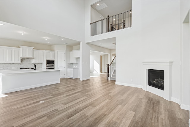 unfurnished room featuring ceiling fan, a towering ceiling, and carpet floors