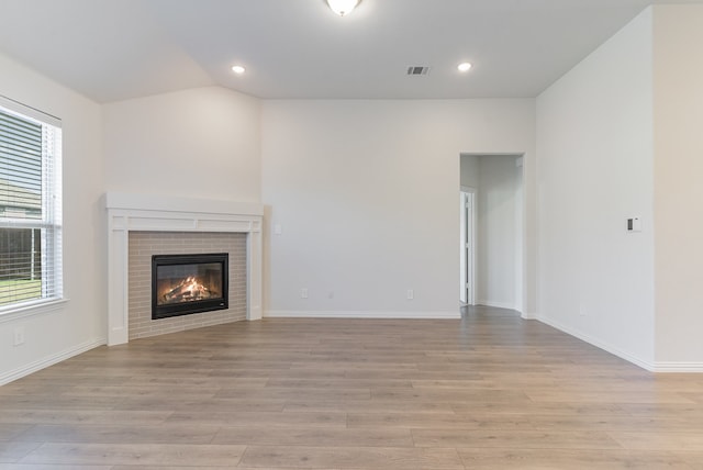 unfurnished living room featuring plenty of natural light and light hardwood / wood-style floors