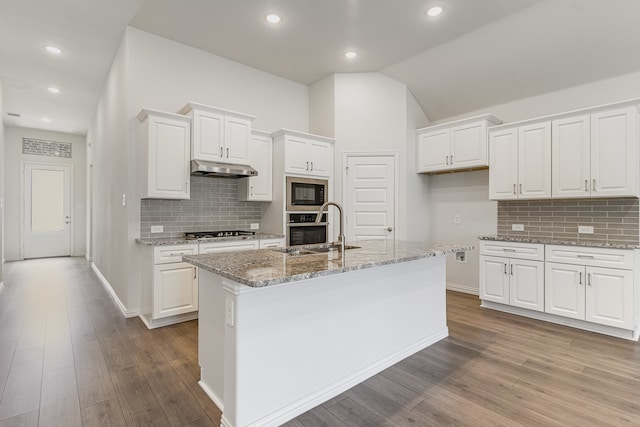 kitchen with white cabinets, sink, light hardwood / wood-style flooring, an island with sink, and appliances with stainless steel finishes