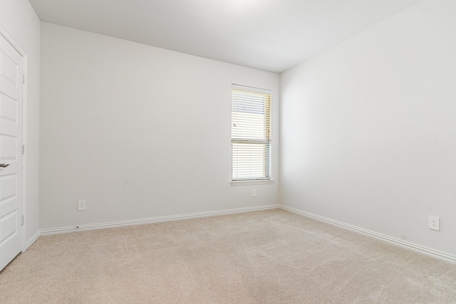 unfurnished room featuring light carpet