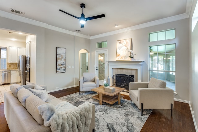 living room featuring plenty of natural light, ceiling fan, dark hardwood / wood-style flooring, and crown molding