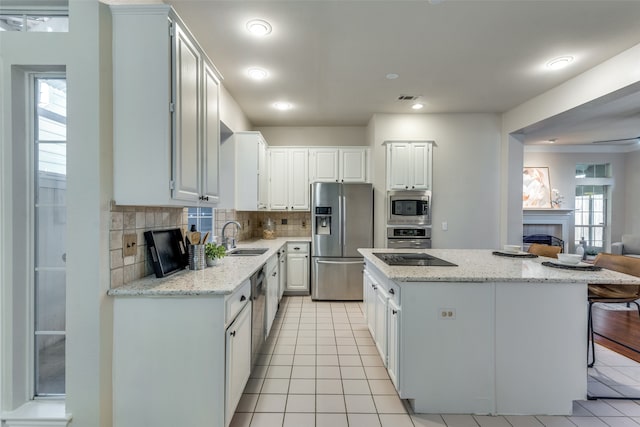 kitchen with a center island, sink, white cabinets, and appliances with stainless steel finishes