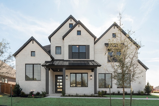 modern farmhouse style home with a front yard and covered porch