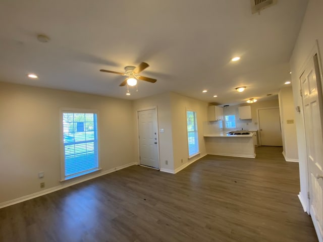 unfurnished living room with ceiling fan and dark hardwood / wood-style floors