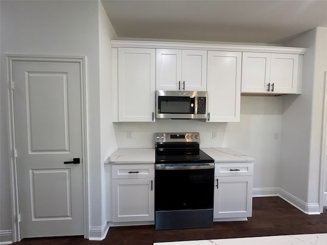 kitchen featuring light stone countertops, white cabinetry, stainless steel appliances, and dark wood-type flooring