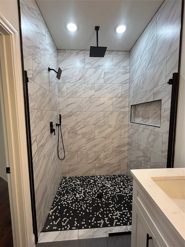 bathroom with vanity and a tile shower