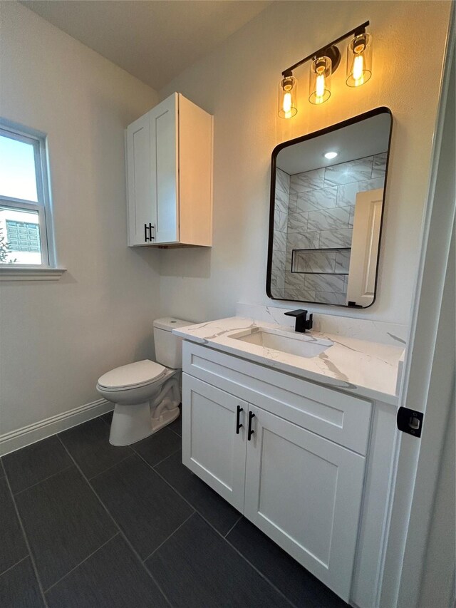 bathroom with toilet, vanity, and tile patterned floors