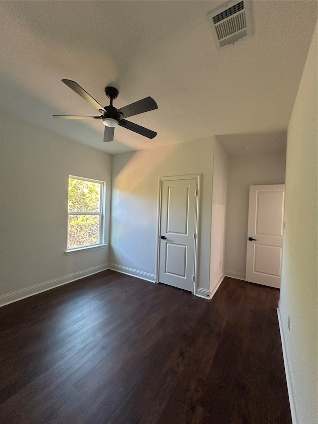 unfurnished room featuring ceiling fan and dark wood-type flooring