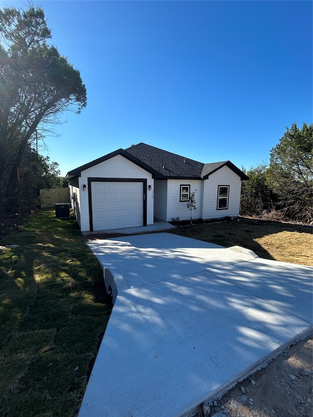 single story home with a garage and a front lawn